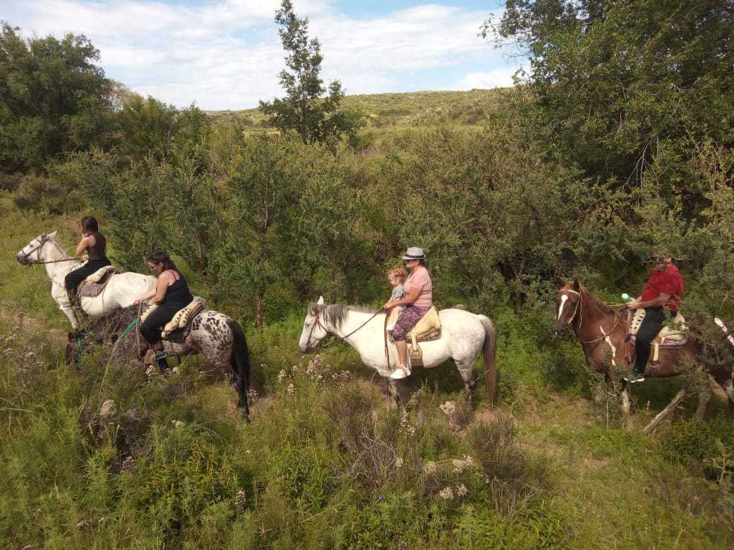Jinetes en fila entre el monte serrano